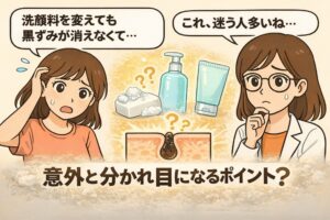 洗顔料を変えても黒ずみが消えない悩みをテーマにした日本2Dフラット漫画風アイキャッチ。左側で困惑する女性が「洗顔料を変えても黒ずみが消えなくて…」と話している。中央には石けん・ポンプ式洗顔料・チューブ型洗顔料のイラストと、角栓が詰まった毛穴の断面図。右側には白衣と眼鏡の女性が考え込む表情で「これ、迷う人多いね…」とつぶやいている。下部に「意外と分かれ目になるポイント？」という大きな文字が配置された淡いベージュ背景のイラスト。