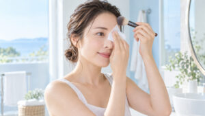 女性がティッシュで皮脂を押さえながらフェイスブラシを使っている様子