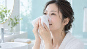 女性が温かいタオルを鼻にそっと当てて毛穴をいたわっている様子